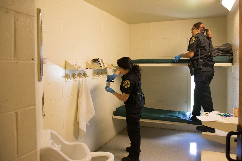 Corrections students inspecting a cell